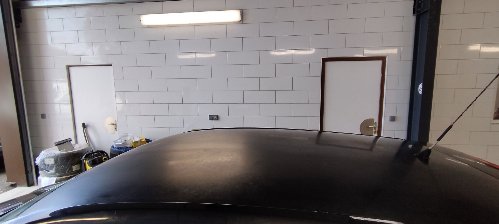 Pavillon d'une Volkswagen Polo noire avant lustrage, la peinture renvoie une lumière diffuse et sans profondeur