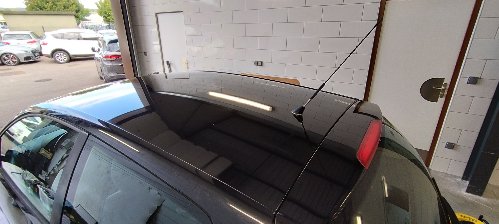 Lunette arrière et becquet d'une Volkswagen Polo noire pendant le lustrage, dans l'atelier d'Envision Auto