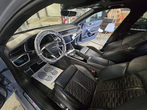 Poste de conduite d'une Audi RS6 : sièges cuir, volant et tapis protégés pendant la prestation