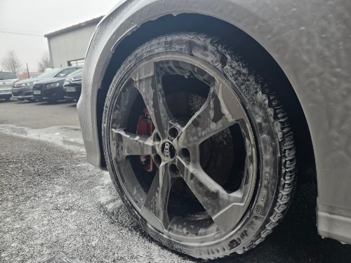 Jante d'une Audi S3 couverte de mousse, étrier de frein rouge visible