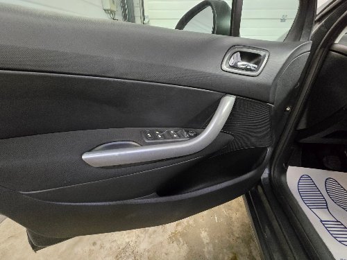 Panneau de porte d'une Peugeot 308 nettoyé, poignée et commandes comprises