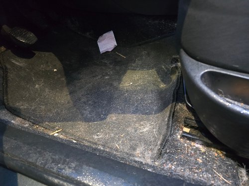 Plancher conducteur d'une Peugeot 308 avant nettoyage, moquette incrustée de terre