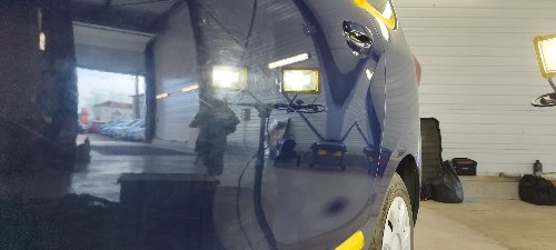 Aile arrière d'un Dacia Lodgy éclairée pour faire ressortir les défauts de peinture