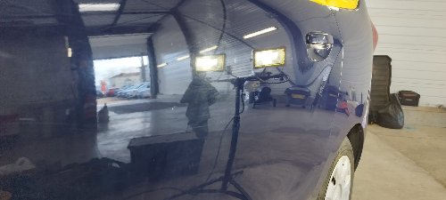 Flanc d'un Dacia Lodgy poli, l'atelier s'y reflète sans voile