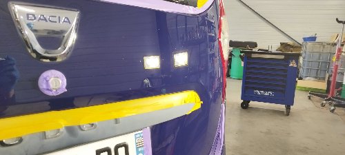 Hayon d'un Dacia Lodgy bleu nuit protégé à l'adhésif pendant le polissage