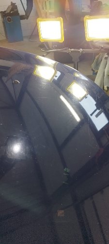 Hayon d'un Dacia Lodgy poli, les lampes d'atelier s'y reflètent nettement