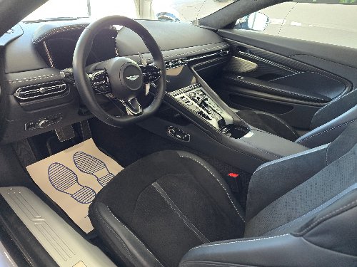Intérieur cuir sombre d'une Aston Martin avec protections de sol