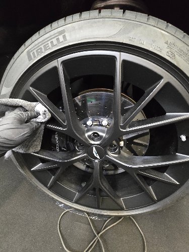 Nettoyage d'une jante Aston Martin au gant microfibre