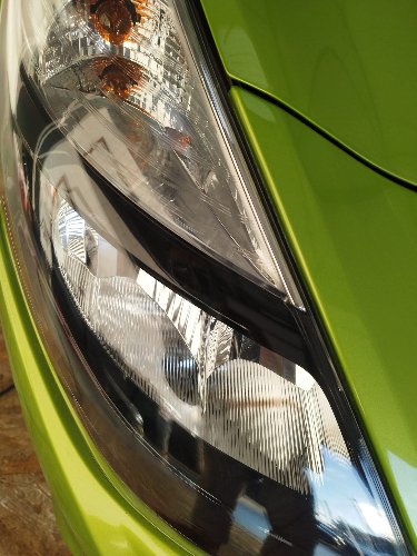 Optique jauni d'une Citroën verte avant ponçage et polissage