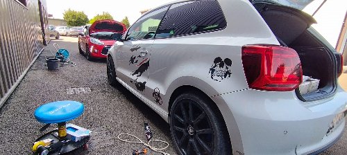 Volkswagen Polo blanche couverte d'autocollants avant intervention